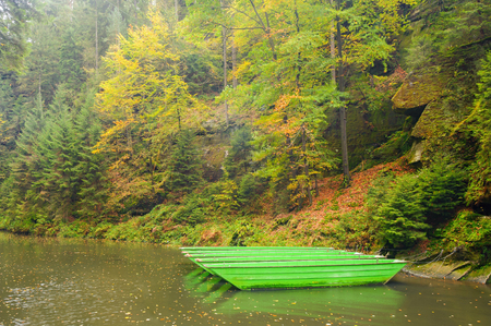 A beautifully clean river flowing through a colorful autumn forestの写真素材