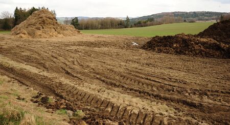 Spring landscape with mud and manure rutted agricultural machineryの写真素材