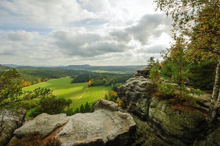 Autumn colorful landscape with forests, hills, sun and skyの写真素材