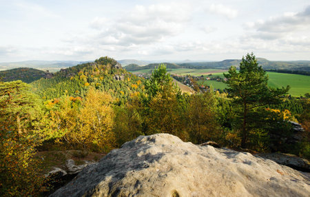 Autumn colorful landscape with forests, hills, sun and skyの写真素材