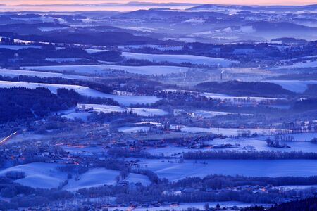 Blue winter landscape, tree forest with snow, ice and rime. Pink morning light before sunrise. Winter twilight, cold nature forest and fields. Orlicke hory, Czech republic. Mountain landscape view.の写真素材