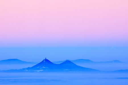 Bezdez hill. Blue winter landscape, tree forest with snow, ice and rime. Pink morning light before...