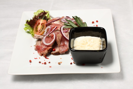 Beef steak with red pepper and black bowl with white sauceの写真素材