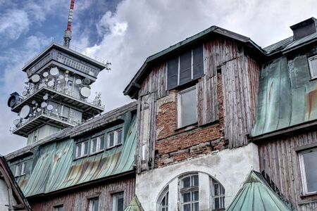 Broken facade of the hut with the broadcasting tower in the backgroundの写真素材