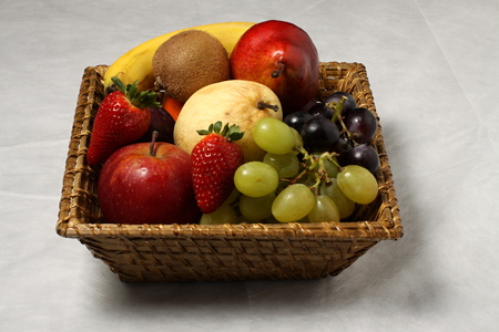 Basket full of exotic and domestic fruitsの写真素材