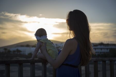 Mother with baby at sunset in summerの写真素材