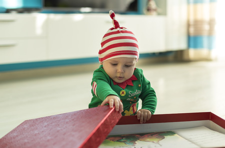 santa helper baby with red gift daytime
