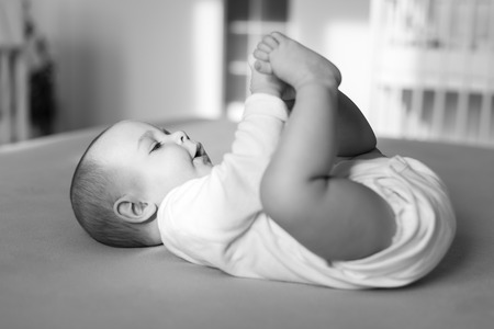 happy baby playing with his feet, black and whiteの写真素材