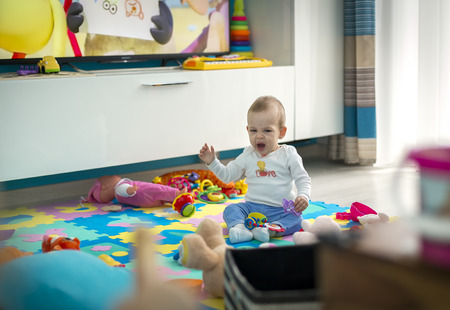 The child with a toy is sleepy and yawningの写真素材