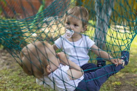 twins relaxing in the hammock on the gardenの写真素材