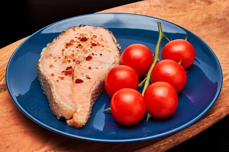 Grilled salmon steak with tomatoes on a branchの写真素材