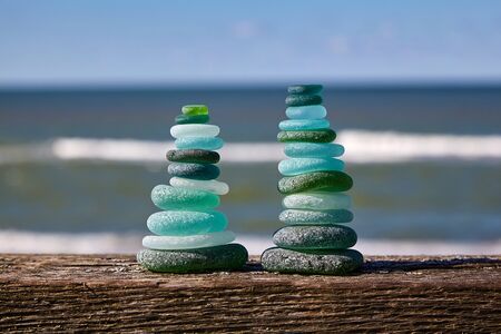 Glass stones on a wooden table against the sea. Two towersの写真素材