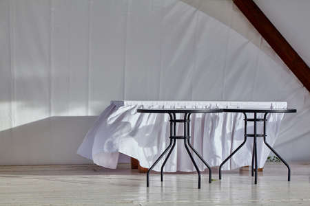A white tablecloth on the table flutters in the breezeの写真素材