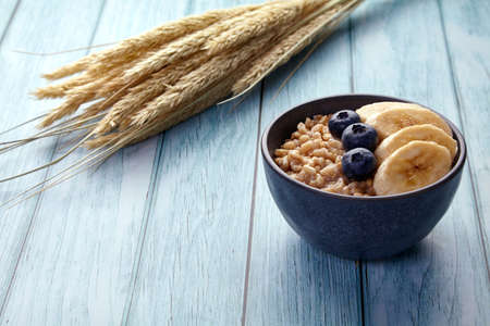 Whole grain oatmeal with blueberries and bananas in a bowlの写真素材