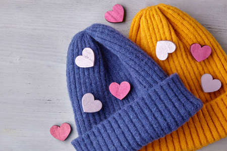 Love and romance concept. Valentines Day. Two knitted blue and yellow hatsの写真素材