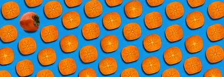 Pattern of slices ripe orange persimmon on a blue backgroundの写真素材