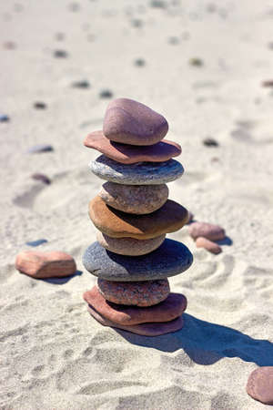 Pyramid of stones on a sandy beach. Zen balance stones