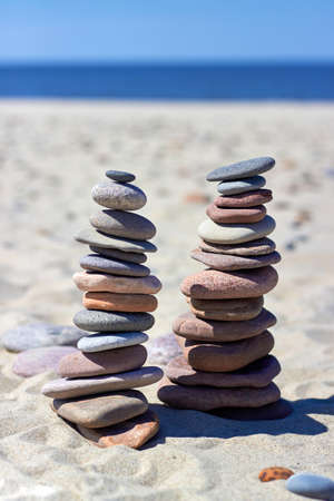 Two pyramids of stones on a sandy beach. Zen balance stones