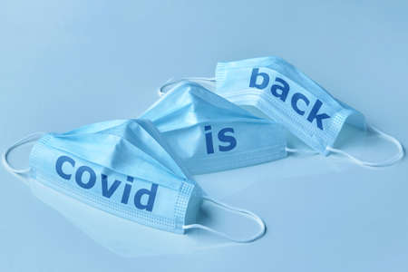 Medical protective mask with the lettering Covid is back. A new wave of OMICRON infections