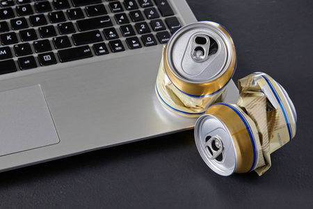 Empty crumpled beer cans on a laptop keyboard on a black background. Drunk conflicts in social networks. family divorcesの写真素材