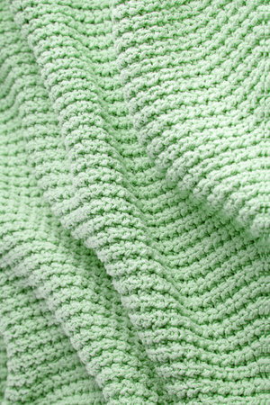 Turquoise green blanket in a large coarse knit with folds. Backdrop for designの写真素材