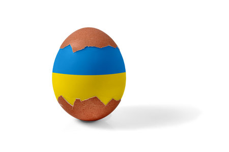 Half shelled Easter chicken egg painted blue and yellow and isolated on a white background.