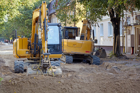 Two excavators on a construction site for road repair work. Excavation work before laying asphalt...