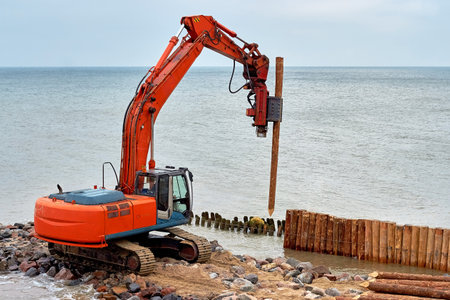 A machine for driving wooden breakwaters on the seashore. Construction work to restore a breakwater...