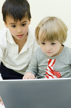 Two children staring at laptopの写真素材