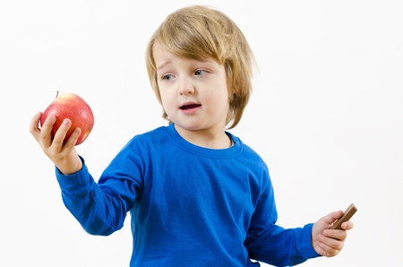 A perplexed blond boy fighting with food temptationの写真素材