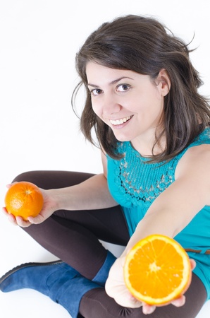 A young beautiful woman holding orangesの写真素材