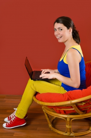Young smiling woman browsing on laptop at homeの写真素材