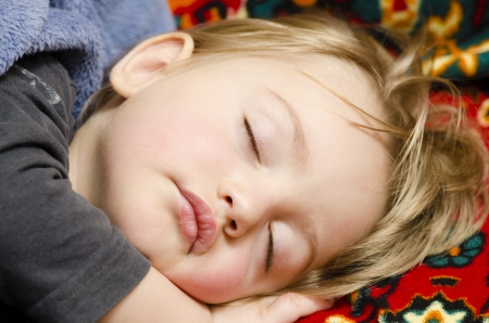 A cute baby boy sleeping in his bedroomの写真素材