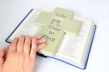 clasped hands for pray on a bible