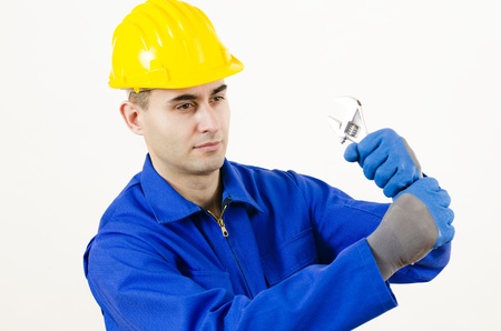A man wearing protective equipment holding adjustable wrench