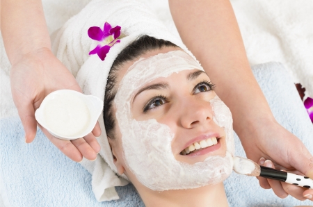 Attractive young woman getting a facial mask in the beauty spaの写真素材