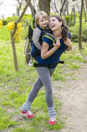 A young woman trekking with her baby pointing somewhereの写真素材