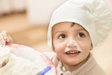 A sweet child playing in the kitchenの写真素材