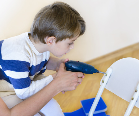 Little Boy using diy tool being helped by parent at homeの写真素材