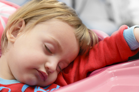 Cute baby boy sleeping in a high chairの写真素材