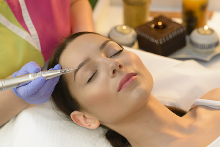 Attractive woman getting laser tattoo procedure at beauty salonの写真素材