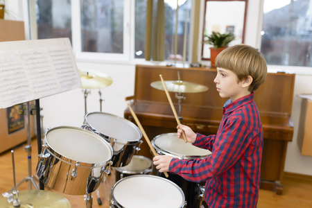 Kid studying drums at schoolの写真素材