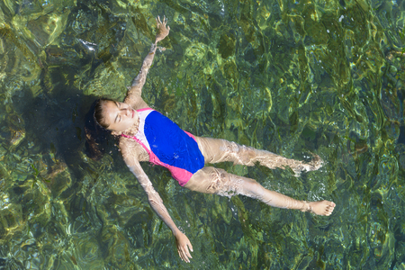 Floating on her back at sea, summer dayの写真素材