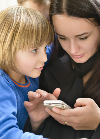 Mother and kids enjoying smartphoneの写真素材