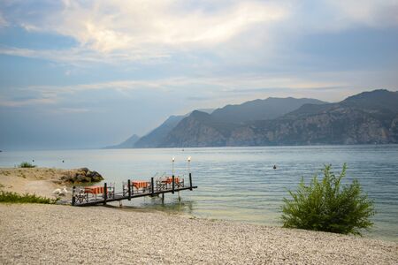 Evening view of romantic restaurant on lake surounded by mountains summer dayの写真素材