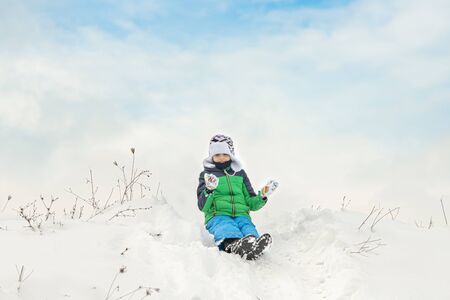 Cute kid enjoying winter time playing with snowの写真素材