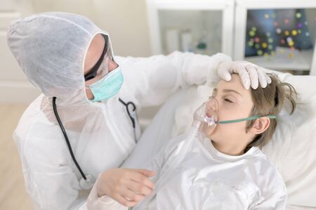 Empathic female doctor treats and intubating a child with respiratory virusの写真素材