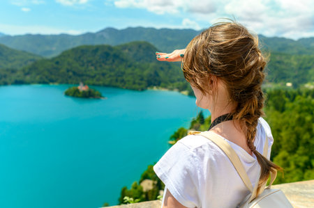 Tourist woman looking ahead to the horizon and enjoying view of lake Bled, Sloveniaの写真素材