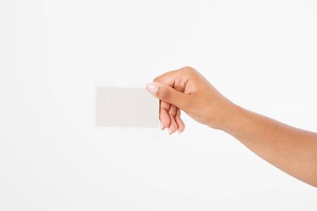 hand hold blank business card. female arm hold paper isolated on white background. copy space. mock up.のeditorial素材