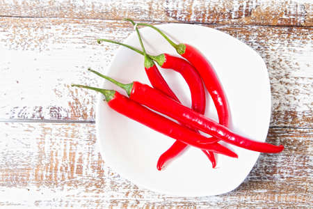 red hot chili pepper on wooden board. Set, copy space, mock up. Cayenne on white plate